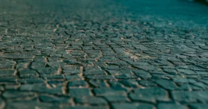 Nierówny chodnik z uszkodzoną nawierzchnią – ryzyko potknięcia i obrażeń